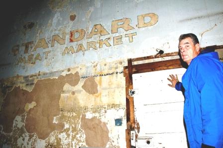 Burt McAnally shows the door to the Standard Meat locker. Standard Meat Company is believed to have been one of the original tenants in the farmer's market.